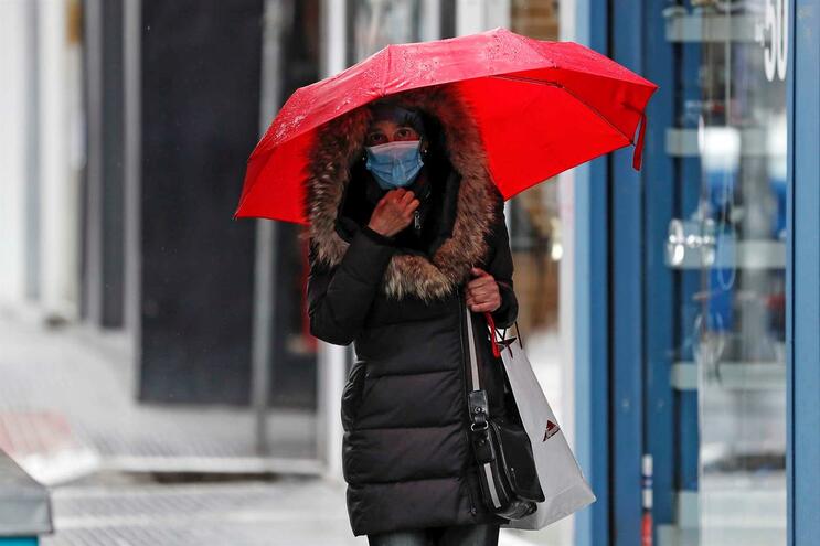 epa08295998 Una mujer que llevaba una máscara protectora camina por una tienda cerrada en una calle central de Salónica