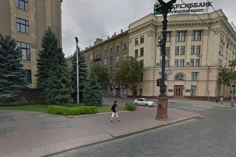 Captura de pantalla de Google Maps de la esquina de un edificio del gobierno en Kharkiv;  hay una mujer caminando, un carro parado, unos arboles y el cielo esta nublado