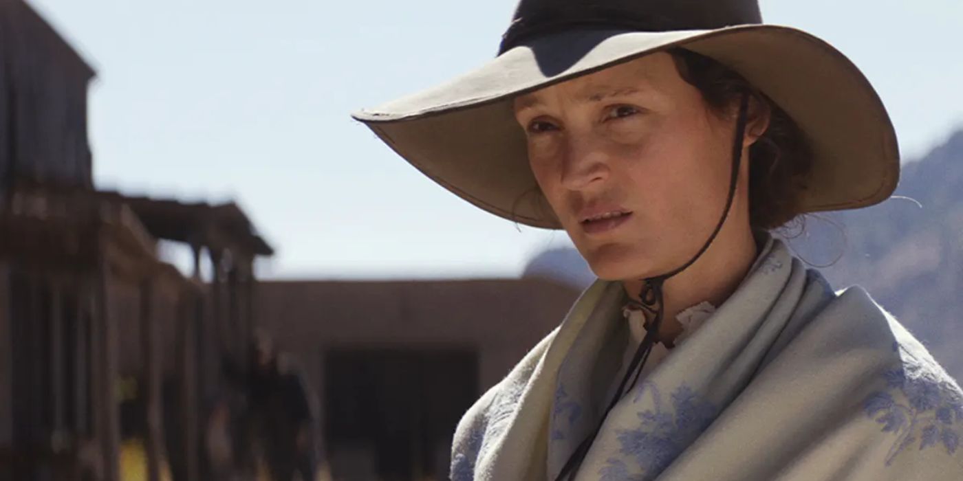 Vicky Krieps como Vivienne Le Coudy con un gran sombrero y una bufanda en el oeste en The Dead Don't Hurt